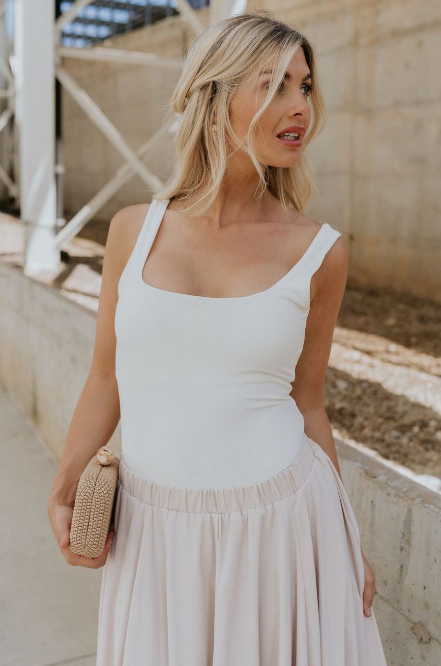 Front view of female model wearing the Mira Scooped Back Sleeveless Bodysuit which features Square Neckline, Thick Straps, Scoop Back and Thong Bottom with Button Snap Closure. the bodysuit is available in black and white