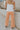 Back view of female model wearing the Kennedy Apricot Orange Wide Leg Pants which features Orange Denim Stretch Fabric, Cropped Wide Pant Leg, Front Zipper with Button Closure, Belt Loops, Two Front Pockets andTwo Back Pockets