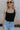 close up view of female model wearing the Leigh Square Neckline Sleeveless Tank which features Ribbed Lightweight Fabric, Square Neckline and Sleeveless. the tank is available in white and black.