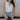 Front view of female model wearing the Emilia Satin Plunge Neckline Sleeveless Bodysuit which features Satin Fabric, Surplice Neckline with Button Snap, Sleeveless and Thong Bottom with Button Closure. the bodysuit is available in taupe and white