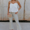 Full body view of female model wearing the Raelynn Sage Wide Leg Pants which features Light Sage Denim Fabric, Wide Pant Leg, Raw Hem, Front Zipper with Button Closure, Two Front Pockets, Two Back Pockets and Belt Loops 