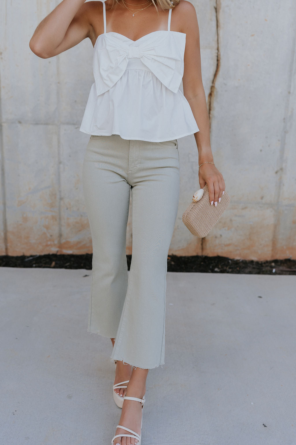 Front view of female model wearing the Raelynn Sage Wide Leg Pants which features Light Sage Denim Fabric, Wide Pant Leg, Raw Hem, Front Zipper with Button Closure, Two Front Pockets, Two Back Pockets and Belt Loops