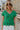 front view of female model wearing the Leia Green Knit Ruffle Short Sleeve Top which features Kelly Green Knit Fabric, Ruffle Details, Scalloped V-Neckline and Short Sleeves with Ruffle Layer Hem