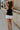 full body back view of female model wearing the Lianna Black Sleeveless Tank which features Black Lightweight Fabric, Black Lining, Round Neckline and Sleeveless