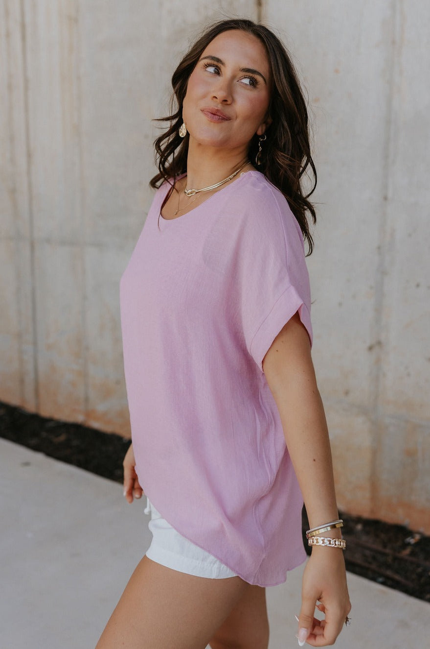 Sideview of female model wearing the Haisley Pink Mauve Short Sleeve Top which features Pink Mauve Lightweight Fabric, Pink Mauve Lining, Round Neckline and Short Sleeves