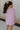 back view of female model wearing the Haisley Pink Mauve Short Sleeve Top which features Pink Mauve Lightweight Fabric, Pink Mauve Lining, Round Neckline and Short Sleeves