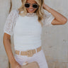 front view of female model wearing the Nylah Ivory Lace Short Sleeve Top which features White Lace Fabric, Lettuce Hem Details, Slight High Neckline and Short Puff Sleeves