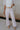 front view of female model wearing the Charli Cropped Wide Leg Pants which features Denim-Like Fabric, Wide Pant Legs, Raw Hem, Monochrome Front Button with Zipper Closure, Two Front Pockets, Two Back Pockets and Belt Loops. the pants are available in blue and pink.