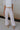front view of female model wearing the Charli Cropped Wide Leg Pants which features Denim-Like Fabric, Wide Pant Legs, Raw Hem, Monochrome Front Button with Zipper Closure, Two Front Pockets, Two Back Pockets and Belt Loops. the pants are available in blue and pink.