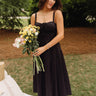Genevieve Black Corset Midi Dress - full body front view - holding flowers