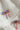 Image shows close-up of Quinn Red, White, & Blue Bow Earrings against a white background. Earrings have red white and blue beads in the shape of a bow, and the center is gold with rhinestones.