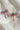 Image shows Quinn Red, White, & Blue Bow Earrings against a white background. Earrings have red white and blue beads in the shape of a bow, and the center is gold with rhinestones.