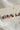 Image shows close-up of bows in Kennedy Stars & Stripes Stud Set that have 3 pairs or studs; bows, circles, and stars. Studs are red white and blue with stripe details.