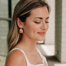 Side view of female model wearing the Monroe Double Gold Hoop Earrings that have attached gold hoops.