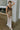 Full body side view of female model wearing the Franceska Taupe Ombre Satin Midi Dress which features Brown Ombre Satin Fabric, Midi Length, Sleeveless, Black Thigh Length Lining and Cowl Neckline
