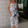 Full body front view of female model wearing the Willow Blue Multi Floral Midi Dress that has a multi-colored floral print, thin straps, a midi hem, and a cowl neckline