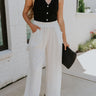 Full body view of female model wearing the Leona Linen Fray Cropped Pants which features Lightweight Fabric, Wide Cropped Leg, Fray Hem Details, Two Front Pockets and Elastic Waistband. the pants are available in blue, green and white.