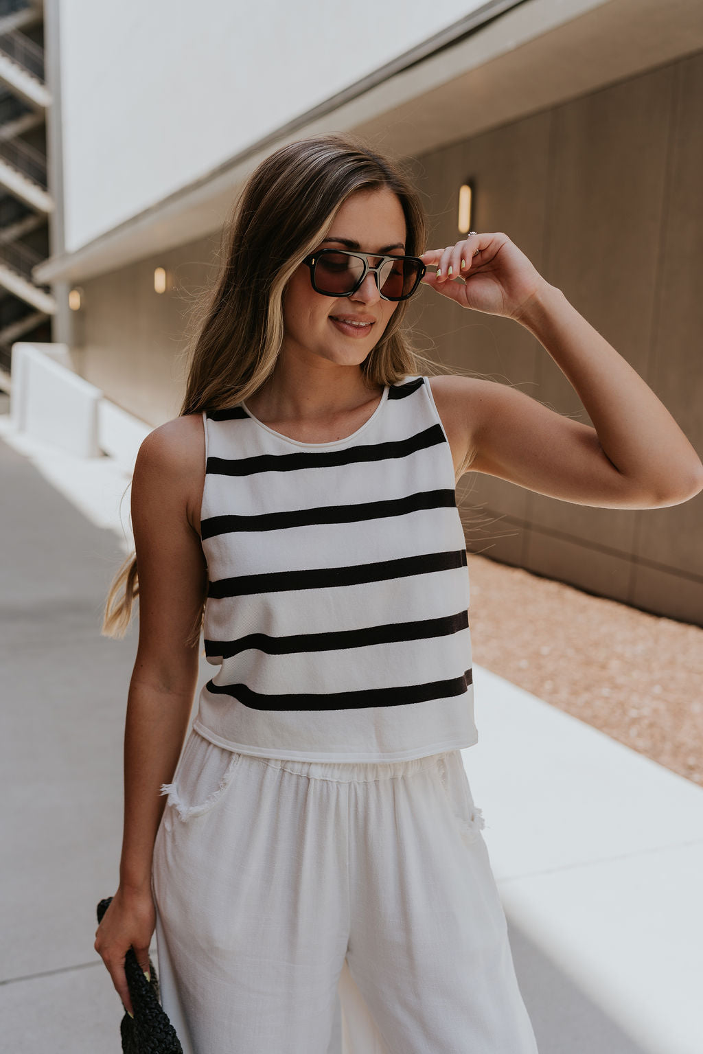 front view of female model wearing the Mallory Off White & Black Stripe Tank which features White and Black Stripe Pattern, Round Neckline, Cropped Waist and Sleeveless