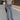 front view of female model wearing the Charli Cropped Wide Leg Pants which features Denim-Like Fabric, Wide Pant Legs, Raw Hem, Monochrome Front Button with Zipper Closure, Two Front Pockets, Two Back Pockets and Belt Loops. the pants are available in blue and pink.