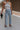 front view of female model wearing the Charli Cropped Wide Leg Pants which features Denim-Like Fabric, Wide Pant Legs, Raw Hem, Monochrome Front Button with Zipper Closure, Two Front Pockets, Two Back Pockets and Belt Loops. the pants are available in blue and pink.