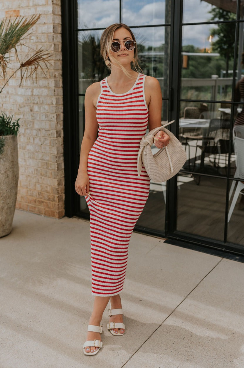 Full body front view of female model wearing the Delilah Red & White Striped Midi DressDelilah Red & White Striped Midi Dress that has horizontal red and white stripes, a round neck, sleeveless, and midi hem.