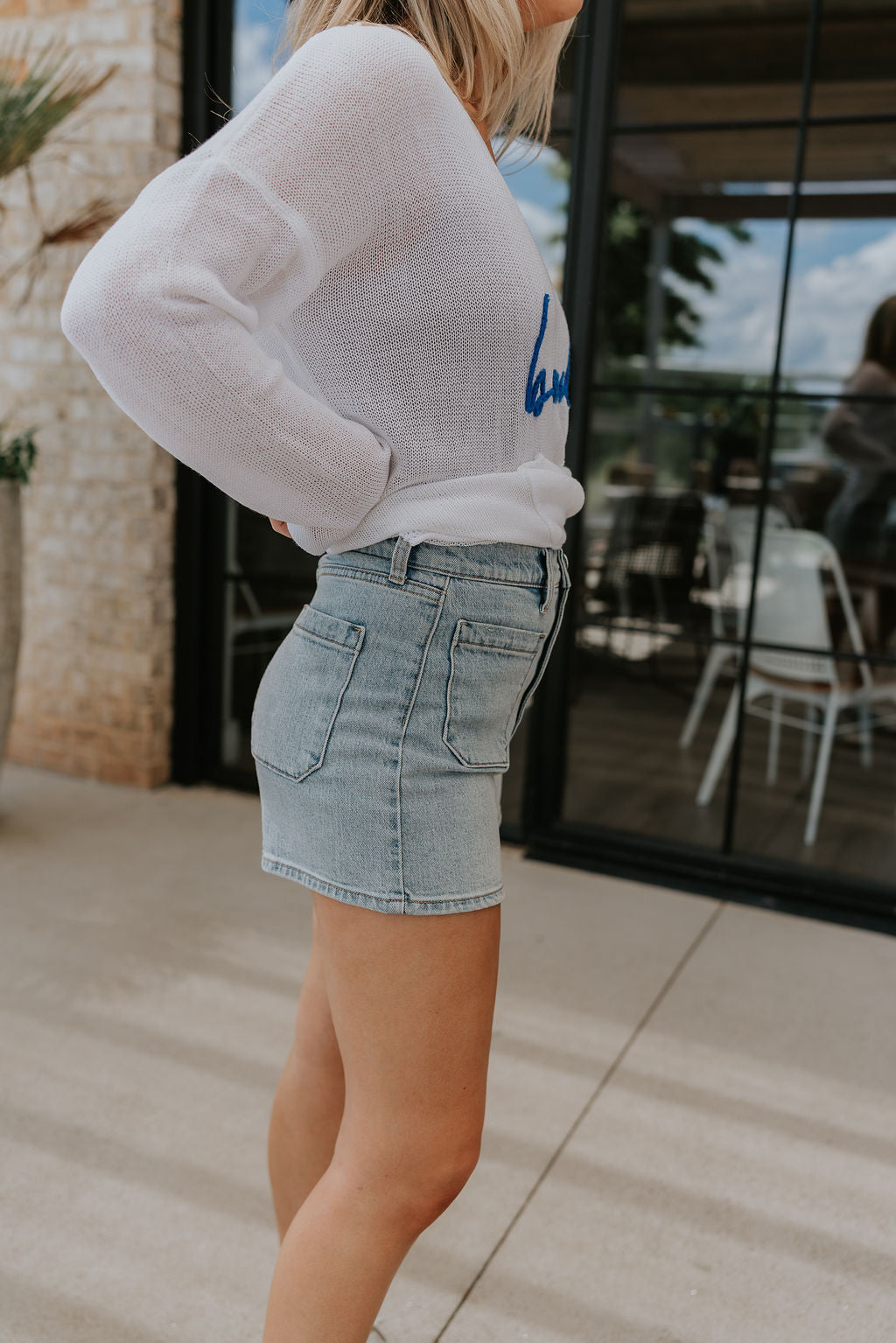 side view of female model wearing the Alyssa Light Wash Denim Shorts which features Stretchy light denim, Front & back pockets and Front zipper & button closure