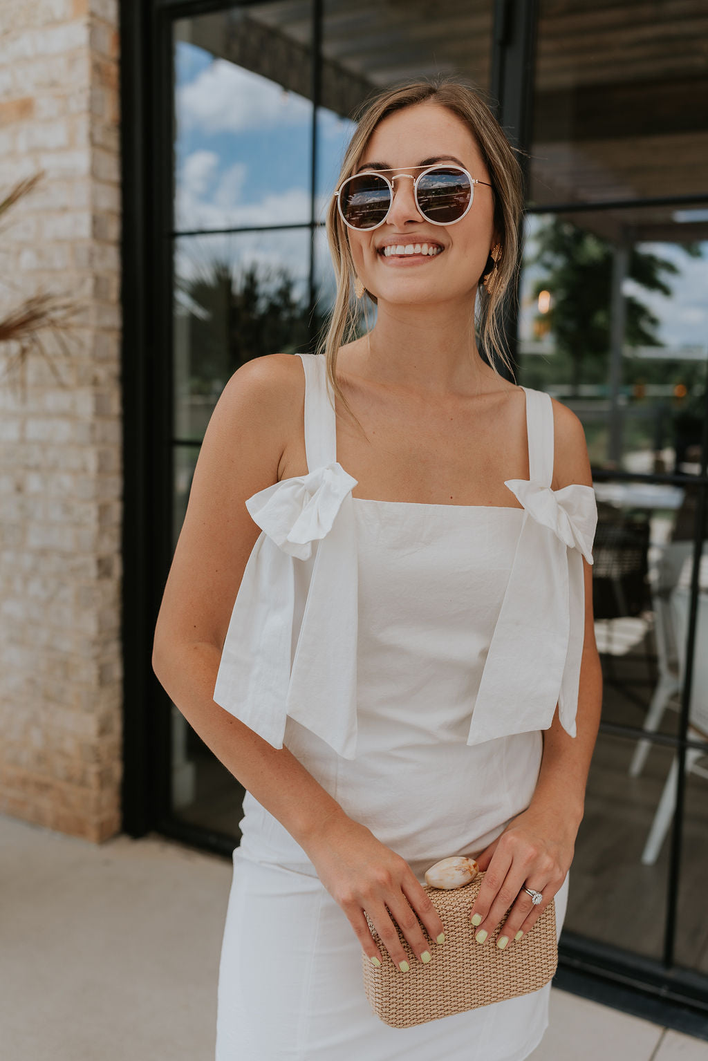 front view of female model wearing the Diana White Bow Straps Mini Dress which features White Cotton Fabric, White Lining, Mini Length, Square Neckline, Bow Details, Thick Straps and Monochrome Back Zipper with Hook Closure