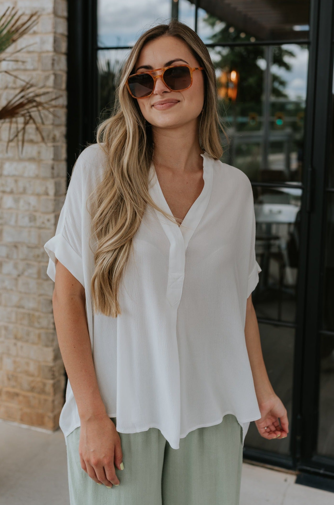 front view of female model wearing the Evie White Short Sleeve Button-Up Top which features Evie White Short Sleeve Button-Up Top