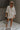 Full body view of female model wearing the Andrea Ecru Button-Up Top which features Ecru Cotton Fabric, Monochrome Button-Up Top, Collared Neckline, Front Left Chest Pocket and Short Sleeves