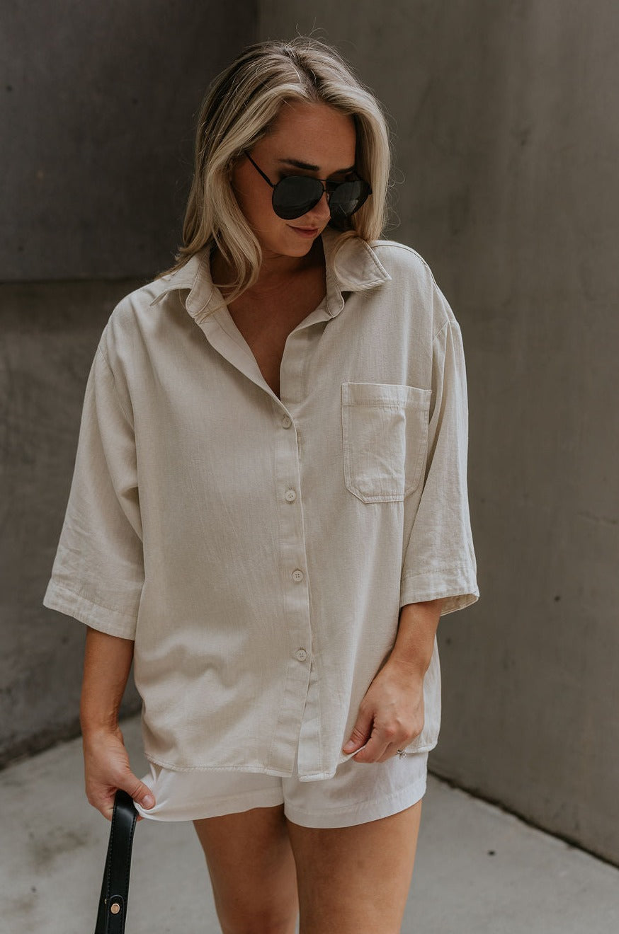 front view of female model wearing the Andrea Ecru Button-Up Top which features Ecru Cotton Fabric, Monochrome Button-Up Top, Collared Neckline, Front Left Chest Pocket and Short Sleeves