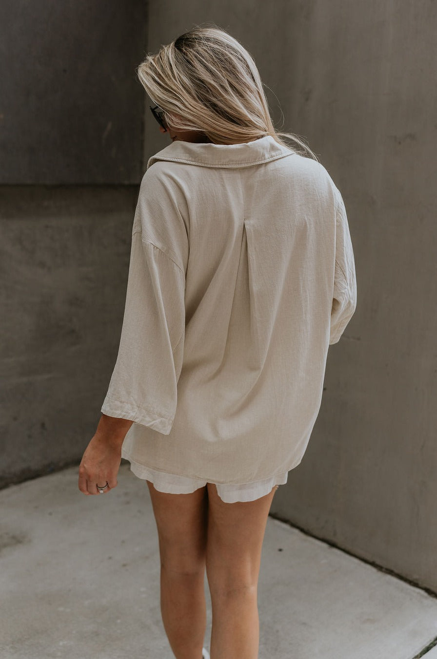 back view of female model wearing the Andrea Ecru Button-Up Top which features Ecru Cotton Fabric, Monochrome Button-Up Top, Collared Neckline, Front Left Chest Pocket and Short Sleeves