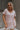 Upper body front view of model wearing the Hadley Light Pink Short Sleeve Top that has light pink knit fabric, a chest pocket, v neck, and short sleeves.