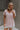 Upper body front view of model wearing the Hadley Light Pink Short Sleeve Top that has light pink knit fabric, a chest pocket, v neck, and short sleeves.