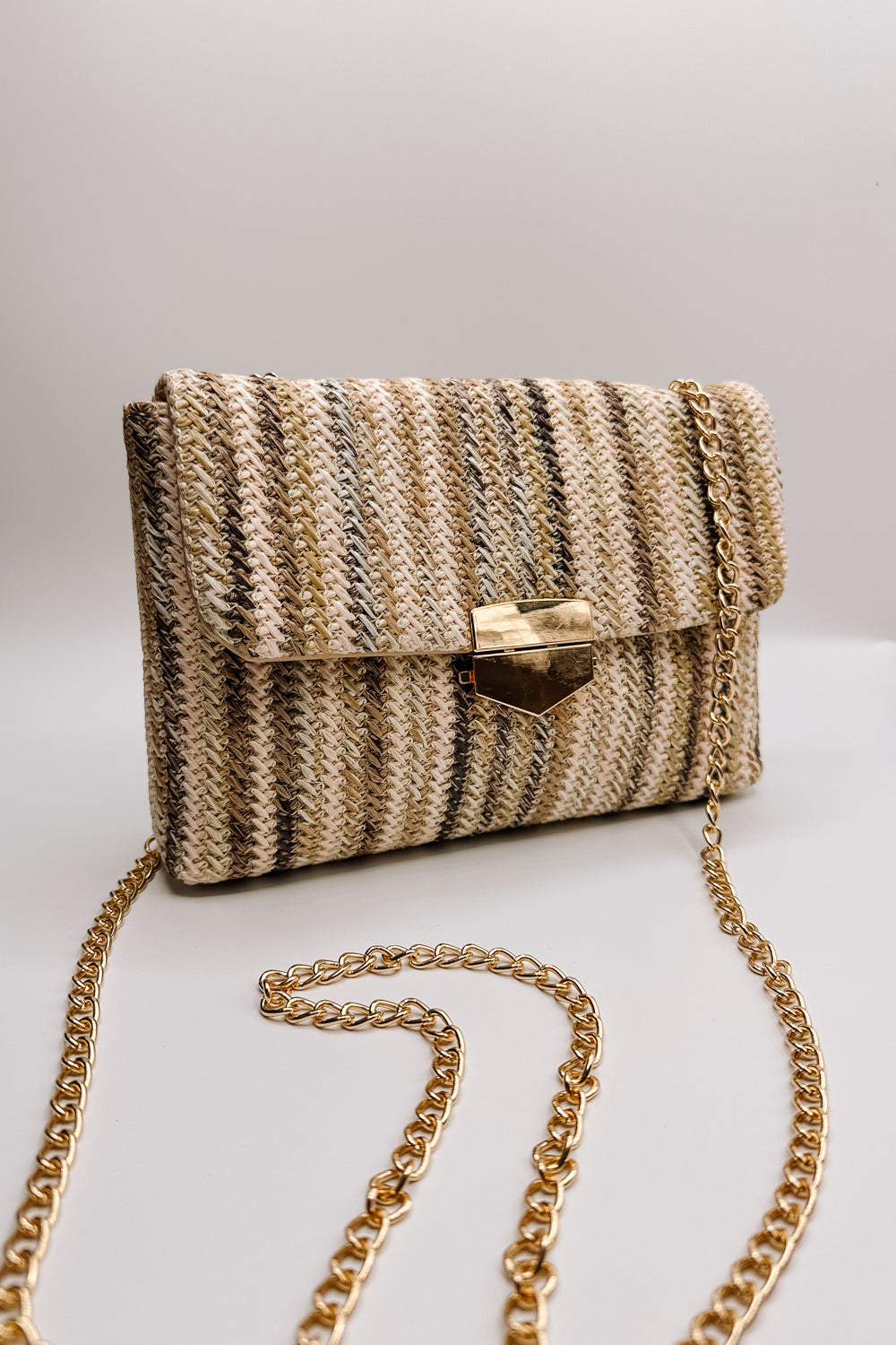 Front view of the Janie Natural Multi Gold Chain Purse which features natural multi woven fabric, gold clasp closure, tan lining, gold hardware and gold chain strap