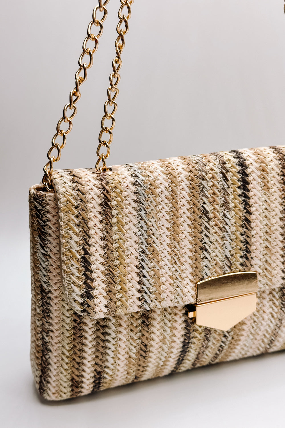 Front view of the Janie Natural Multi Gold Chain Purse which features natural multi woven fabric, gold clasp closure, tan lining, gold hardware and gold chain strap