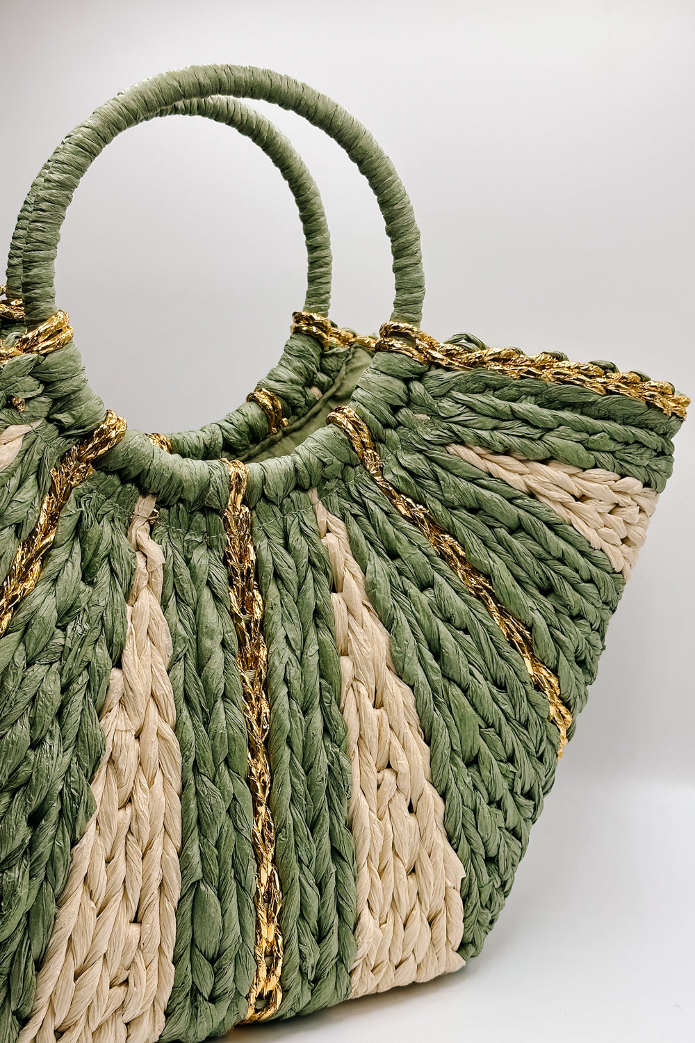 Front view of the Aurora Olive & Natural Woven Tote which features sage and natural woven braided fabric, gold thread details, round handles and sag lining