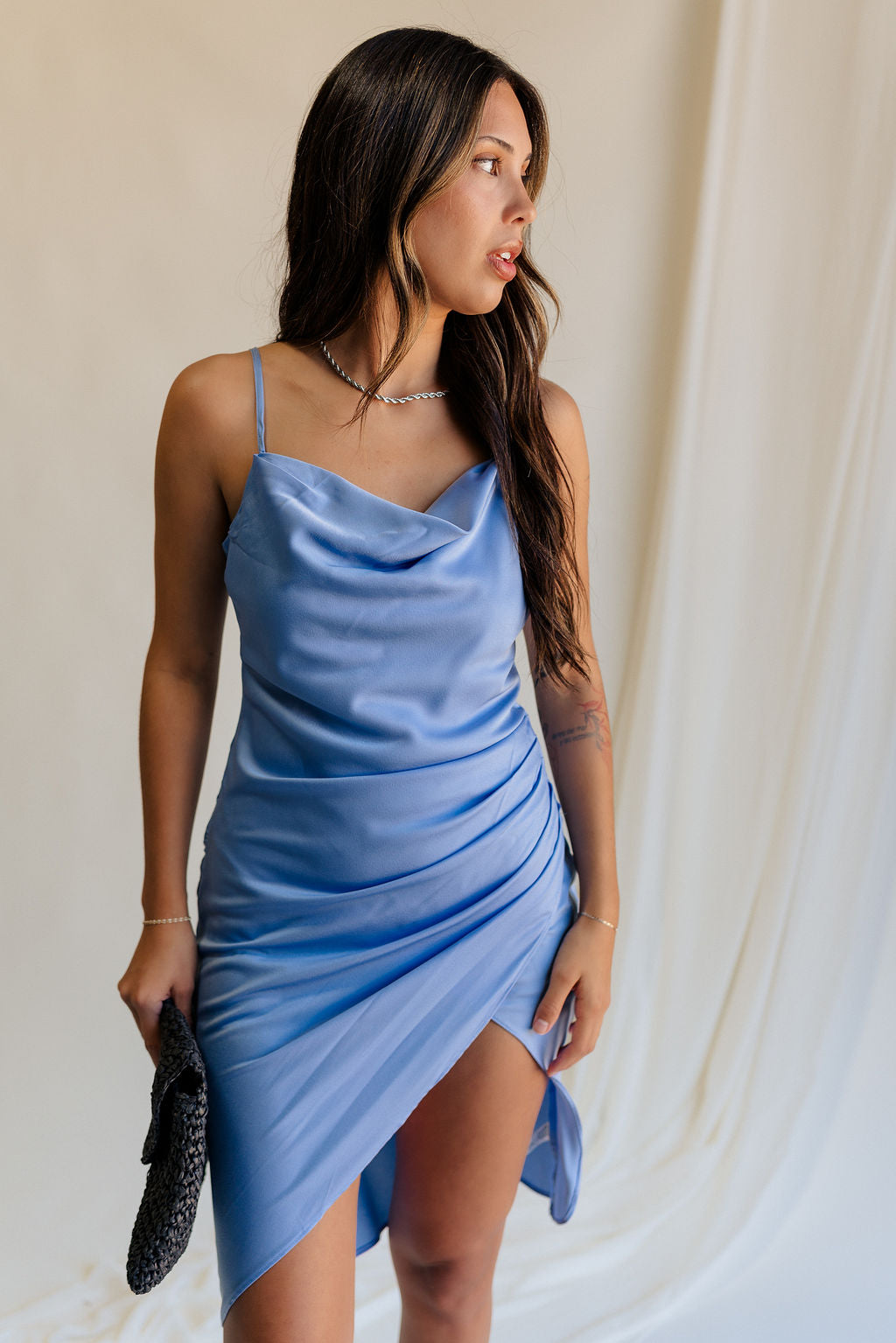 front view of female model wearing the Azlynn Blue Satin Cowl Neckline Dress which features Blue Satin Fabric, Overlay Hem Detail, Ruched Detail, Cowl Neckline with Adjustable Straps and Side Monochrome Zipper with Hook Closure