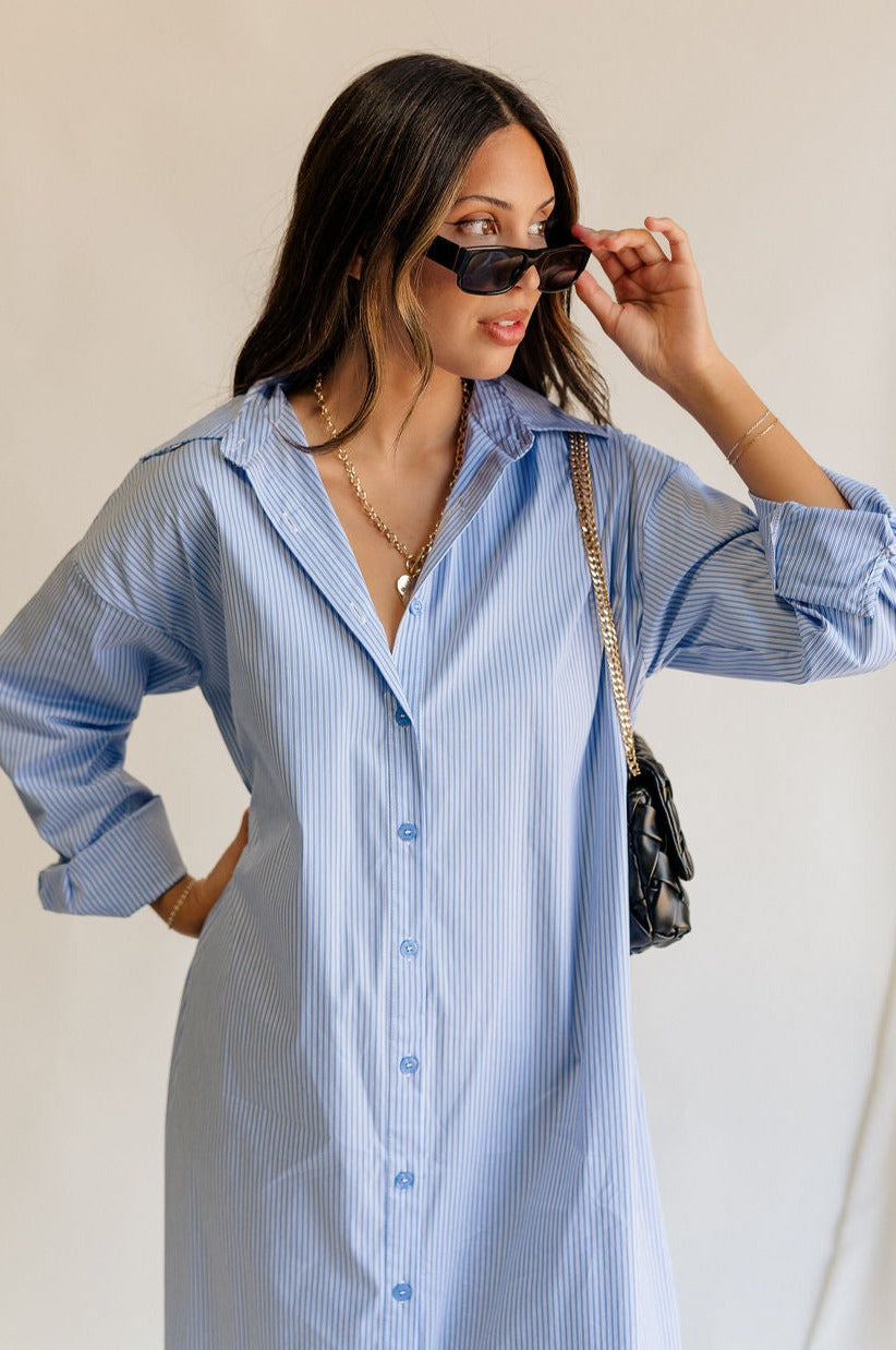 front view of female model wearing the Ryan Blue and White Stripe Button-Up Midi Dress which features Blue and White Stripe Pattern, Side Slit Details, Monochrome Button-Up Front Closure, Collared Neckline and Long Sleeves with Buttoned Cuffs