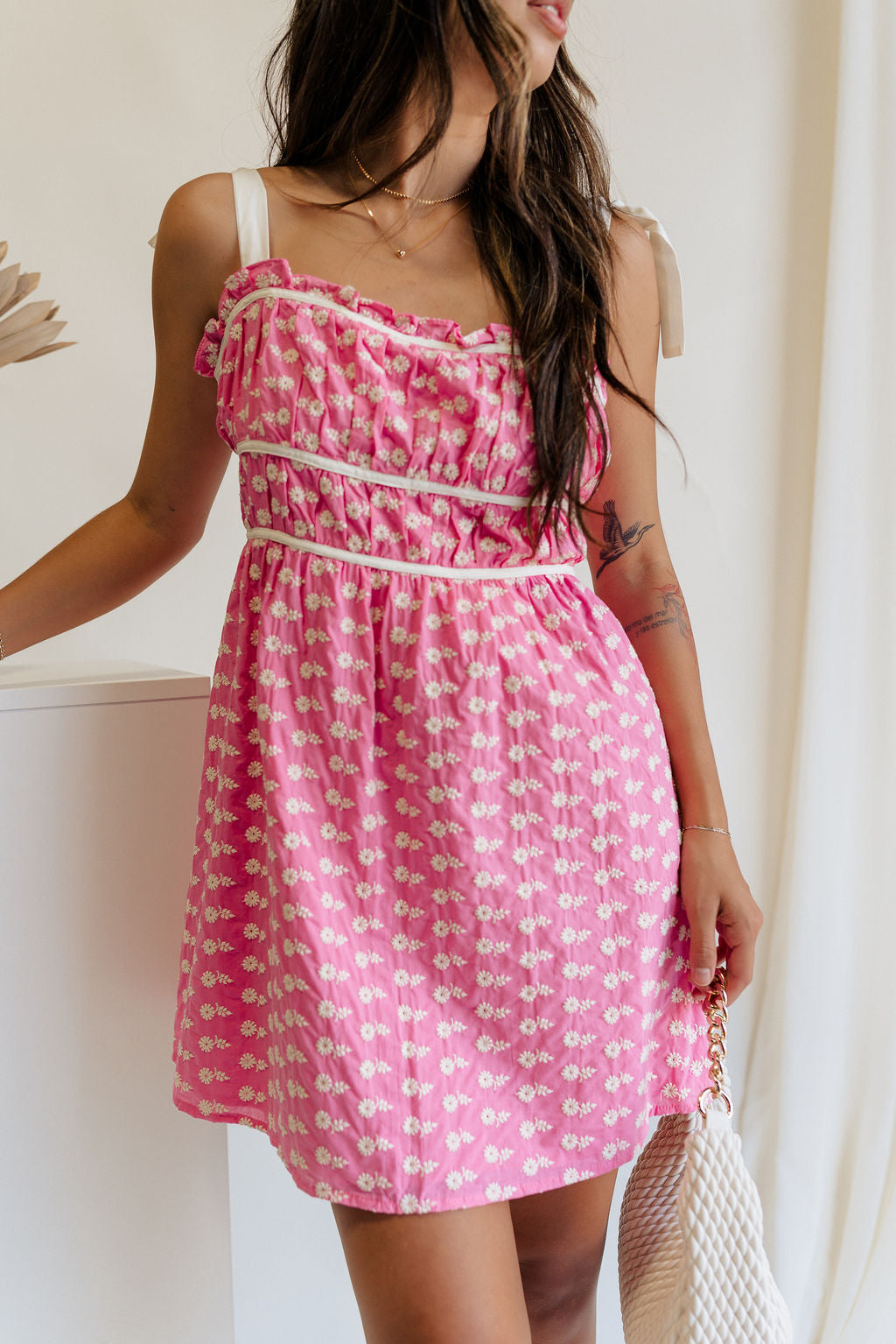 Front view of female model wearing the Caroline Pink & White Floral Mini Dress which features Pink Lightweight Fabric, White Flower Pattern, Pink Lining, Ruffle Sweetheart Neckline, White Tie Straps and Monochrome Back Zipper with Hook Closure