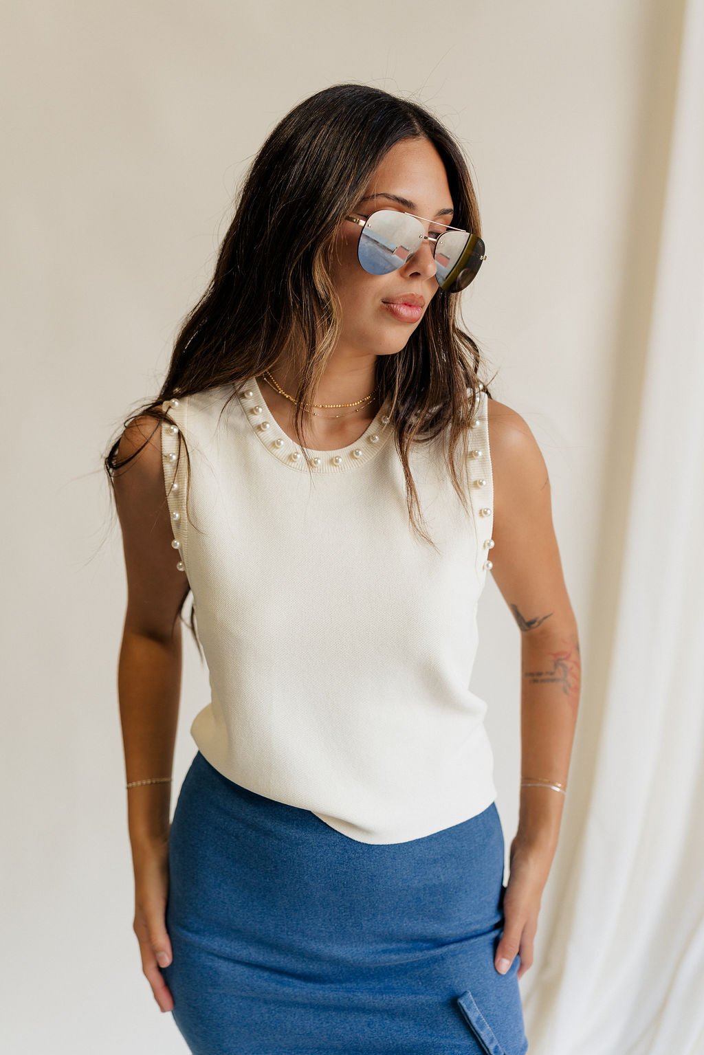 Front view of female model wearing the Brynn Cream Pearl Tank which features Cream Lightweight Fabric, Round Neckline, Pearl Details and Sleeveless