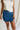 front view of female model wearing the Mylah Denim Slit Bow Mini Skirt which features Medium Denim Fabric, Mini Length, Slit Detail with Bow and Side Monochrome Zipper with Hook Closure