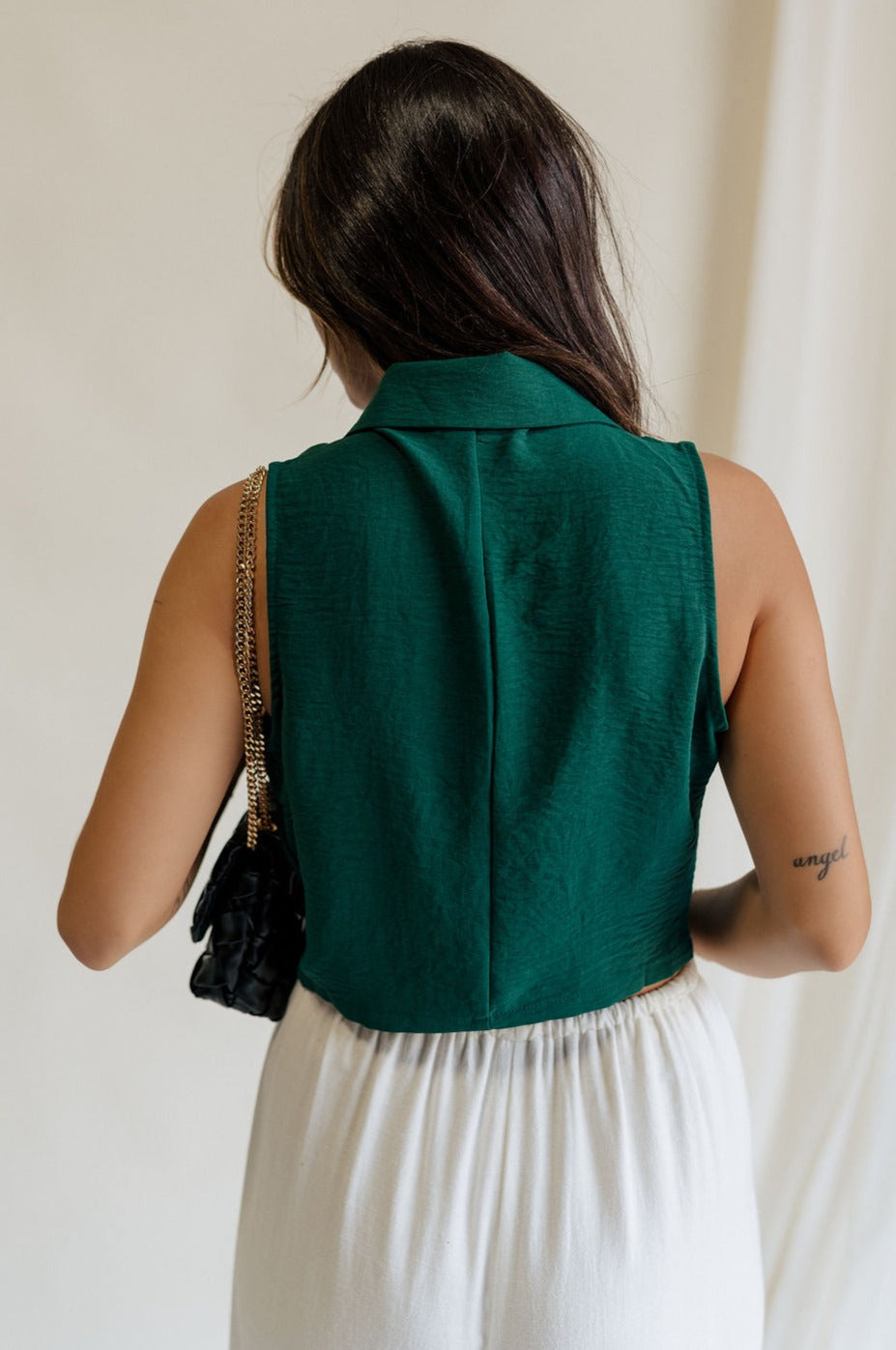 back view of female model wearing the Reign Hunter Green Buttoned Vest which features Hunter Green Lightweight Fabric, Monochrome Button Up, Collared Neckline and Sleeveless