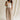 Full body front view of female model wearing the Winnie Brown & Cream Striped Pants, that feature vertical brown and cream stripes, wide legs, and a drawstring waist.