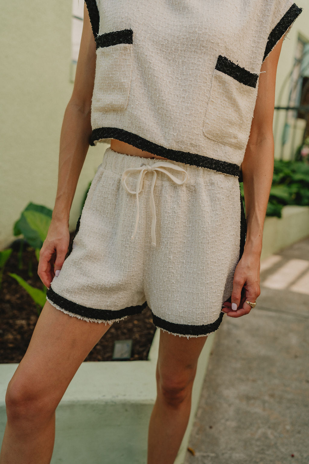 front view of female model wearing the Emery Cream & Black Shorts which features Cream Textured Fabric, Black Trim Details and Elastic Waistband with Drawstring Ties