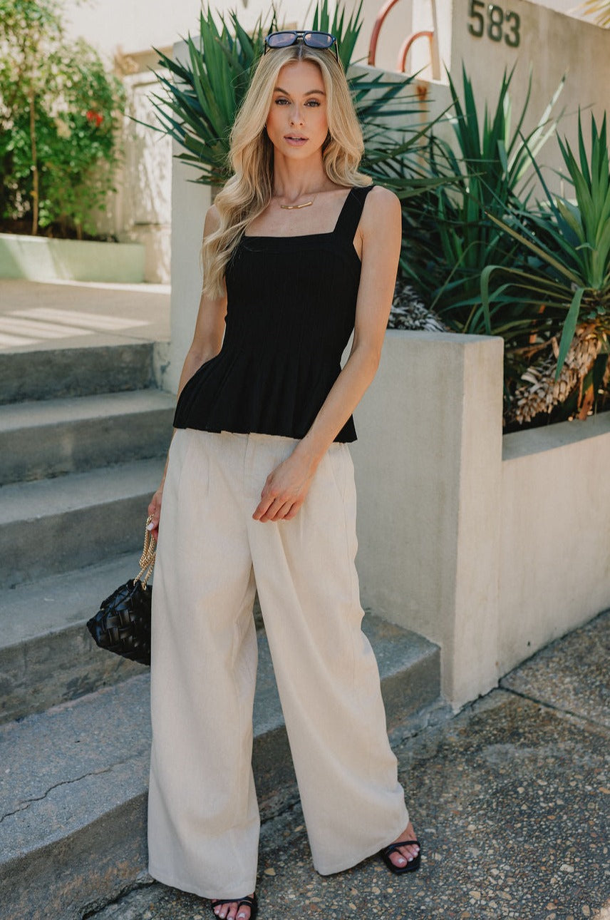 full body view of female model wearing the Juliana Ribbed Flare Tank which features Ribbed Fabric, Flare Hem Detail, Square Neckline, Thick Straps and Sleeveless. the tank is available in black and white.