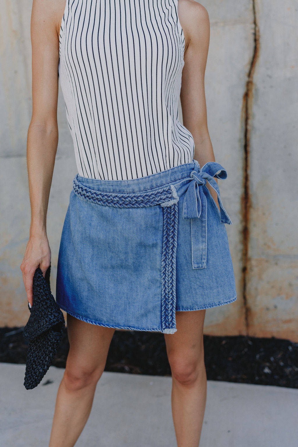 Close up of Molly Medium Wash Denim Skort that has braid details across and a cute tie on the side.