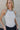Close up front view of Ashley Halter Tank in white with black trim, ribbed sleeveless tank with halter neckline.