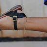 side view of female model wearing the Malia Gold Leaf & Chain Double Anklet which features adjustable gold leaf chain anklet