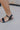 side view of female model wearing the Diana Gold Thick Adjustable Anklet which features adjustable gold thick anklet
