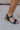 Side view of female model wearing the Londyn Gold Heart Chain Anklet which features gold chain link with a heart medallion
